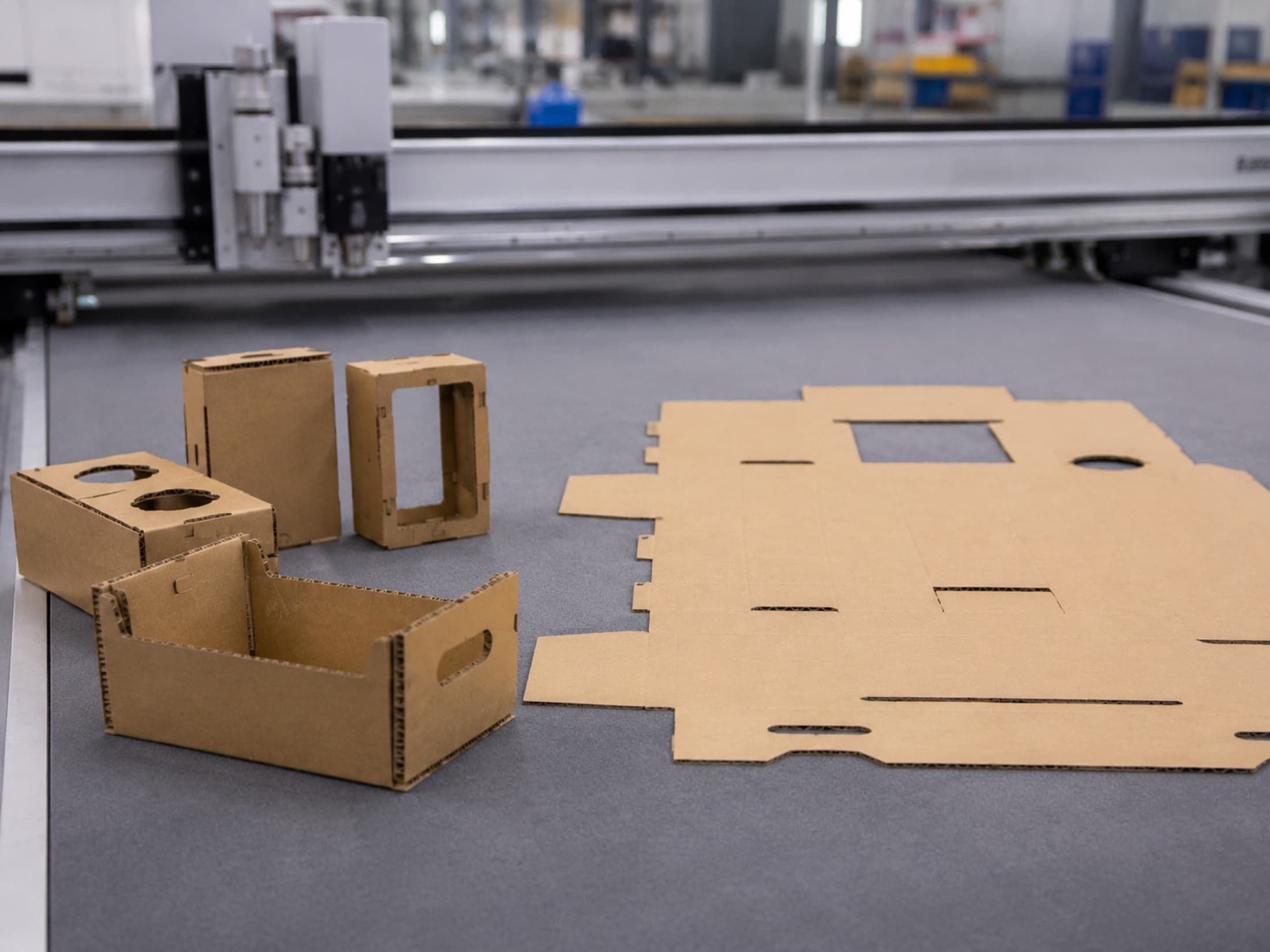 Corrugated prototypes and flat cut parts on a packaging design table
