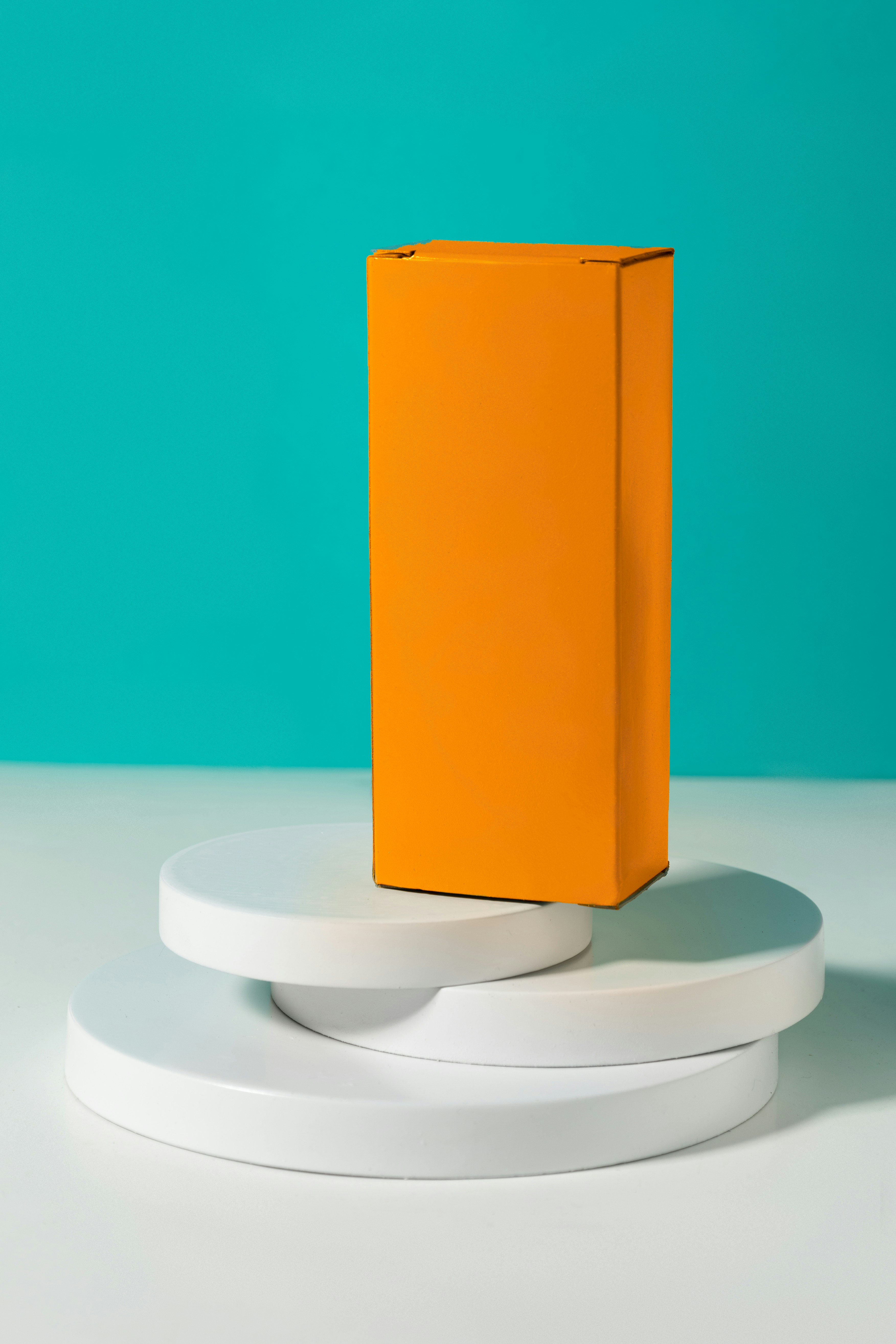Tall orange retail box on white display platforms